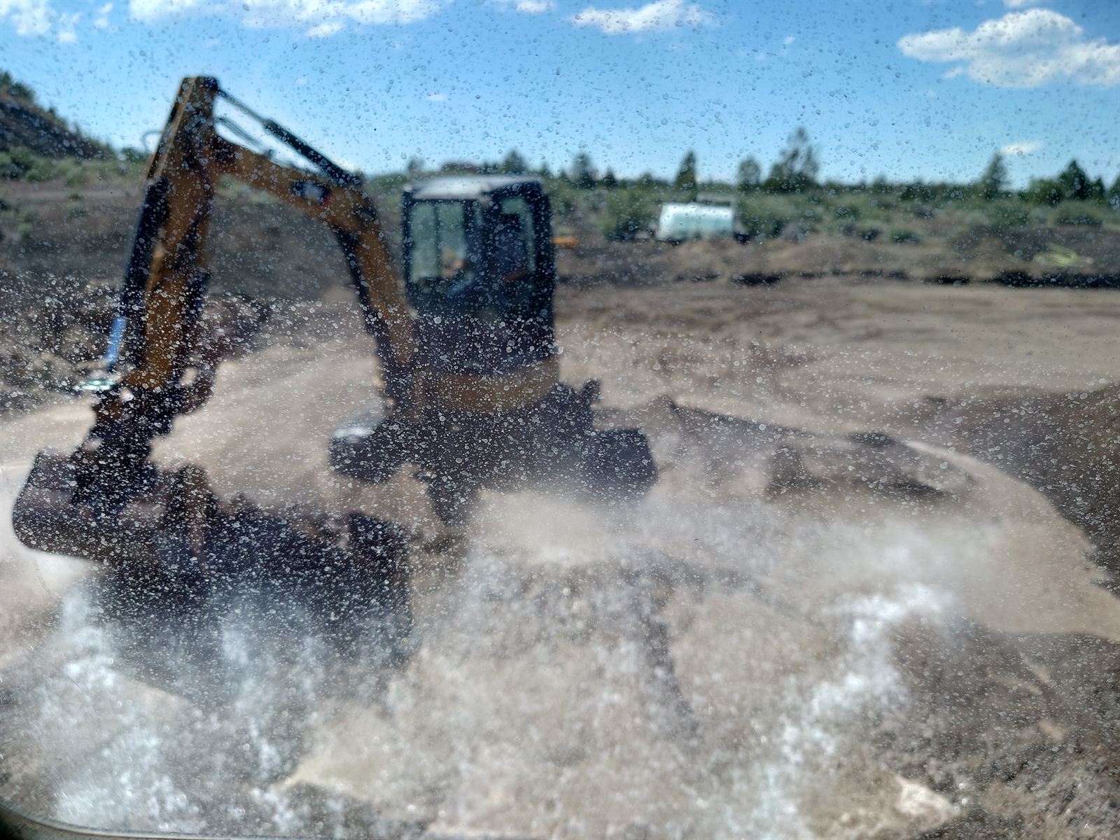 Water spraying across a Central Oregon job site during dust control work
